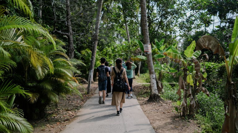 tourists walking in a green environment filled with trees demonstrating eco-conscious travel